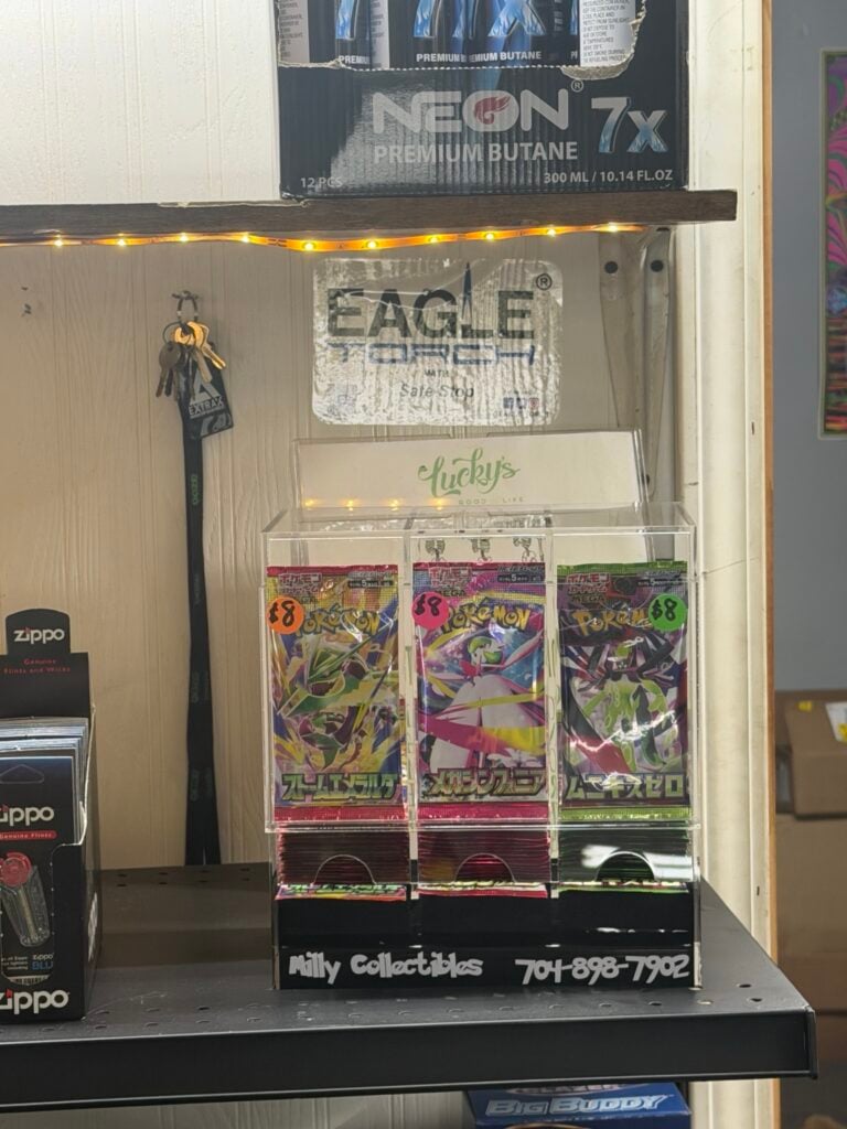 Actual Milly Collectibles three-column Pokémon card display on a store shelf