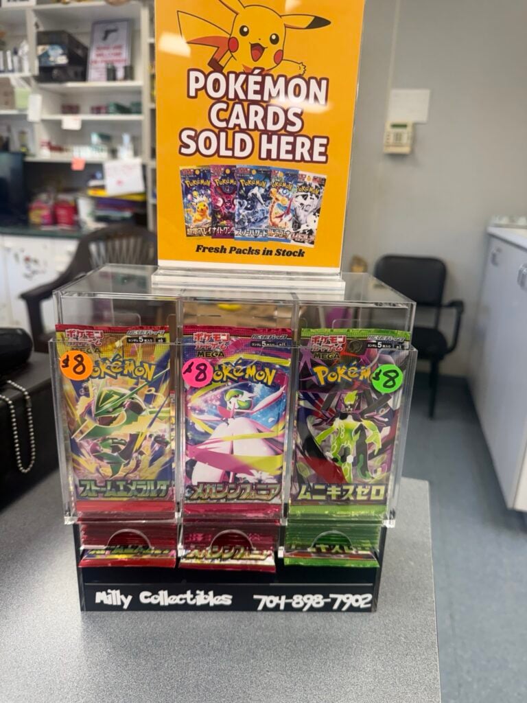 Actual Milly Collectibles Pokémon card display on a store countertop beneath a yellow Pokémon cards sign